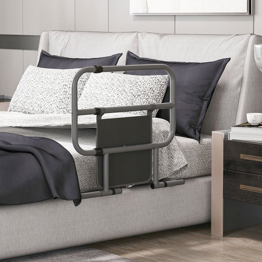 The folding bed rail is placed on a bed next to a headboard and pillows