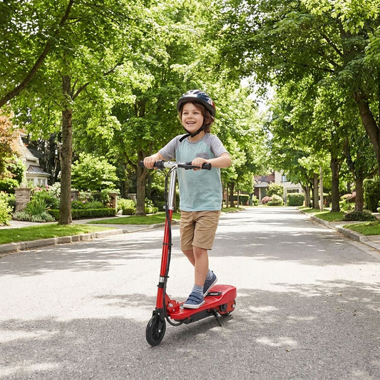 A young boy rides a red electric scooter down a suburban street