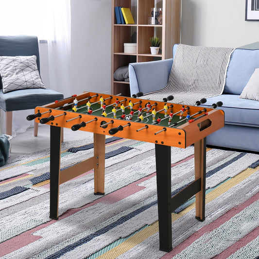 The game table standing in a bright living room with a sofa and patterned rug in the background