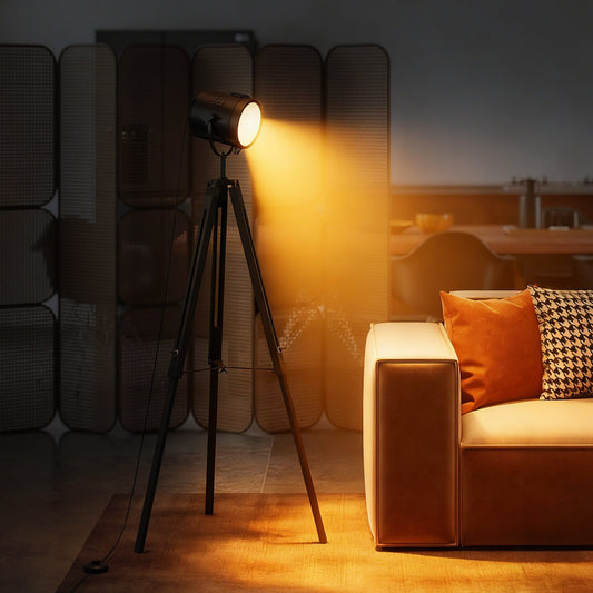 The industrial tripod floor lamp is lit up and casting a warm glow in a stylish living room setting