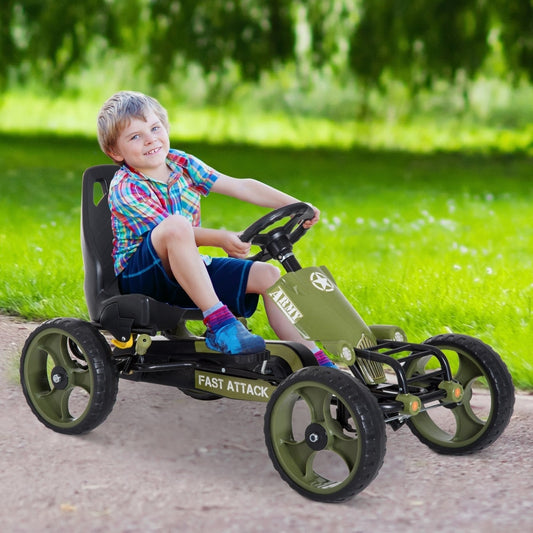A happy young boy driving the green pedal go kart on a grassy lawn