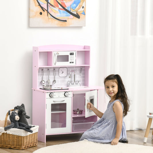 A young girl plays with the pink role play toy kitchen