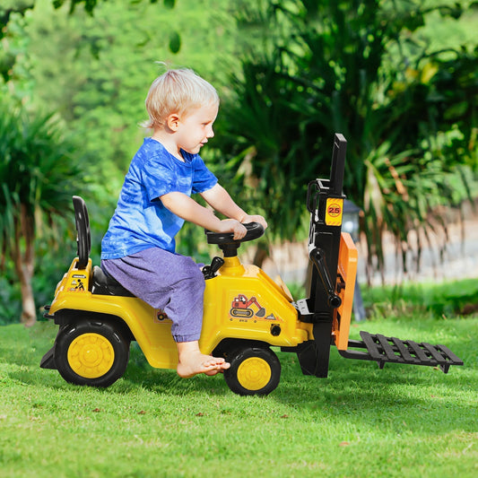 A young boy riding the yellow construction car toy in a garden