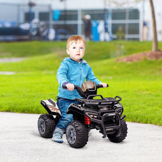 A young boy happily rides the black four-wheeler ATV car on a paved path