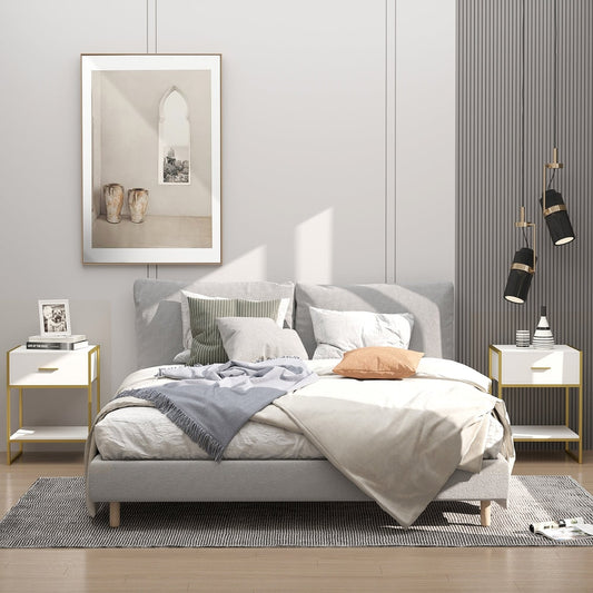 Two white and gold bedside tables in a bedroom setting next to a bed