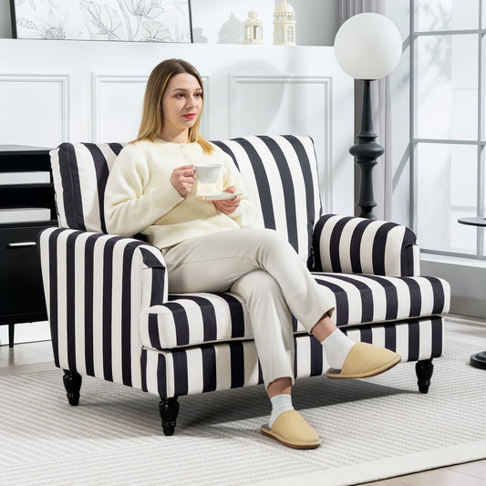 A woman sits on the black and white striped cuddle chair in a living room setting