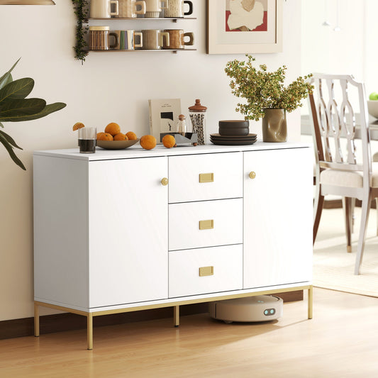 White and gold sideboard in a dining room setting with decorative items