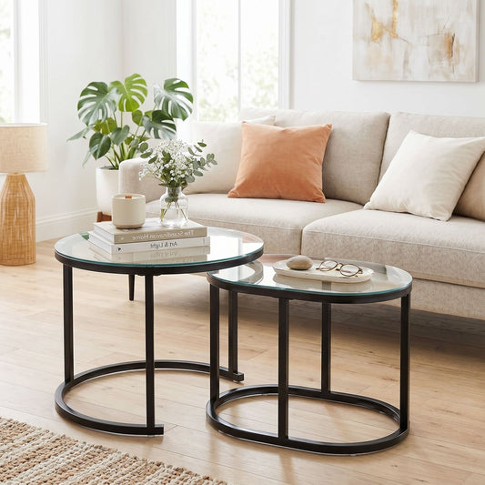 Two modern coffee tables with glass tops and black metal frames arranged in a living room setting