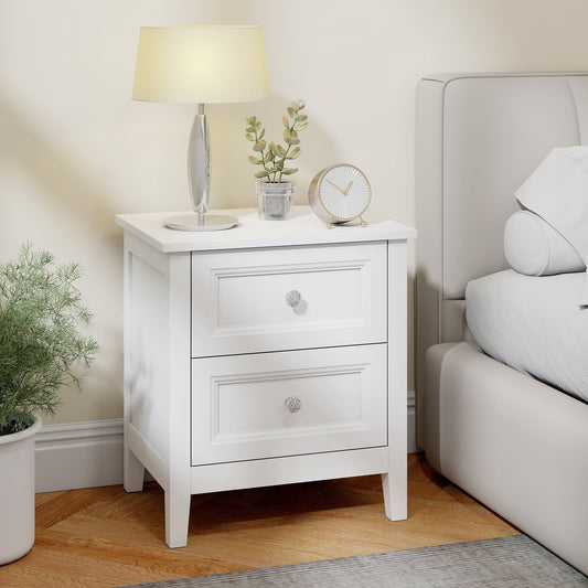 The bedside table placed next to a bed with a lamp and clock on the tabletop in a bedroom