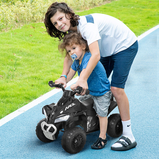 Two boys playing on a black foot-to-floor sliding quad in a park