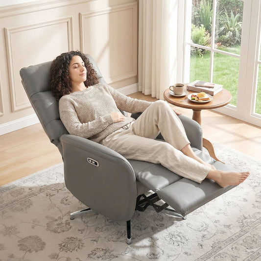 Woman relaxing in the dark grey electric reclining armchair in a bright room