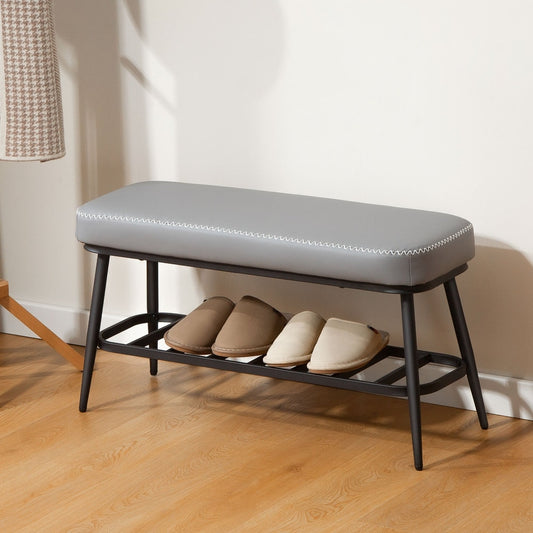 The shoe storage bench with two pairs of shoes on the lower shelf
