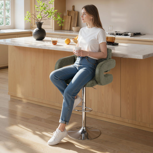 The bar stool in a bright kitchen with a woman sitting on it by the counter