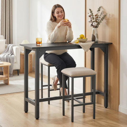A woman sits at the black marble effect bar table enjoying a drink with two stools
