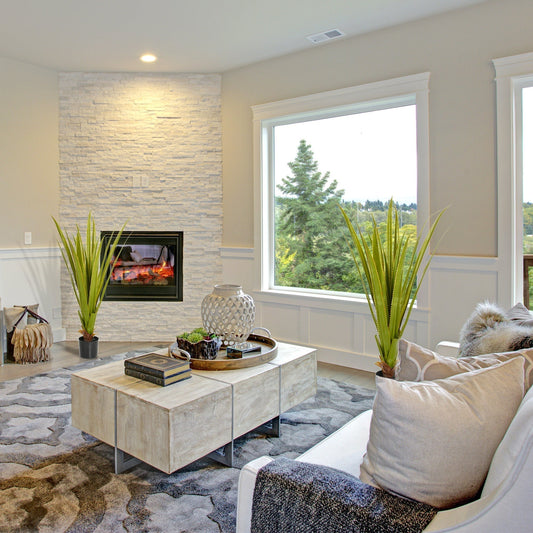 Two artificial agave plants in a modern living room on a coffee table