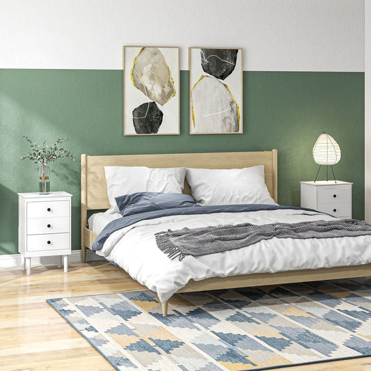 Two white three-drawer bedside tables in a bedroom setting next to a bed