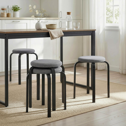 The round backless stools arranged around a dining table in a bright kitchen setting