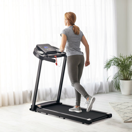 Woman running on the electric motorised running machine in a room