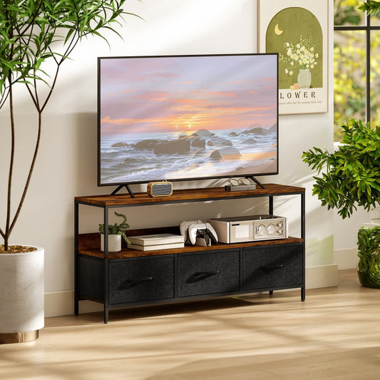 Rustic brown TV unit with three black drawers holding a television and gaming consoles