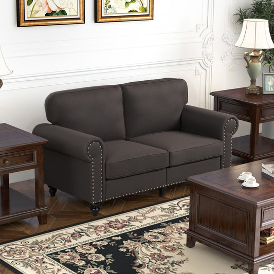 The dark brown two-seater sofa in a living room setting with wooden furniture and a rug