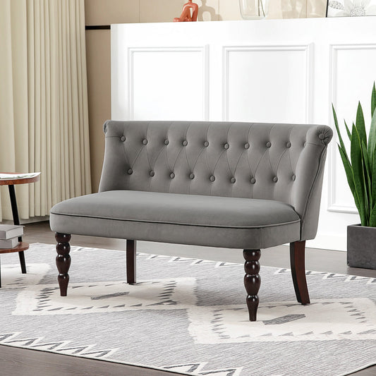 The velvet loveseat placed on a patterned rug in a bright living room setting