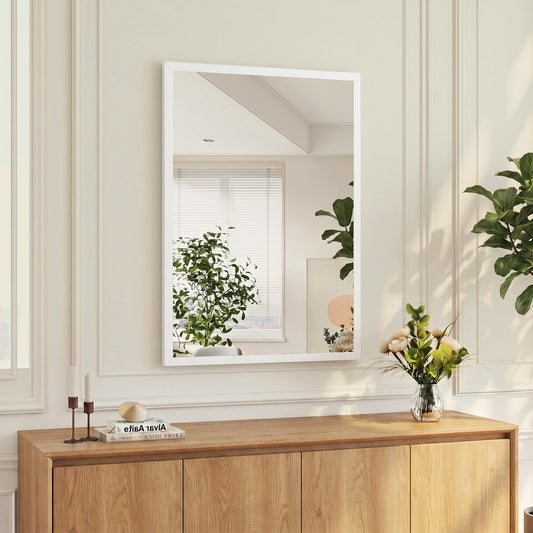 The wall mirror in a room, mounted above a wooden cabinet with decorative items