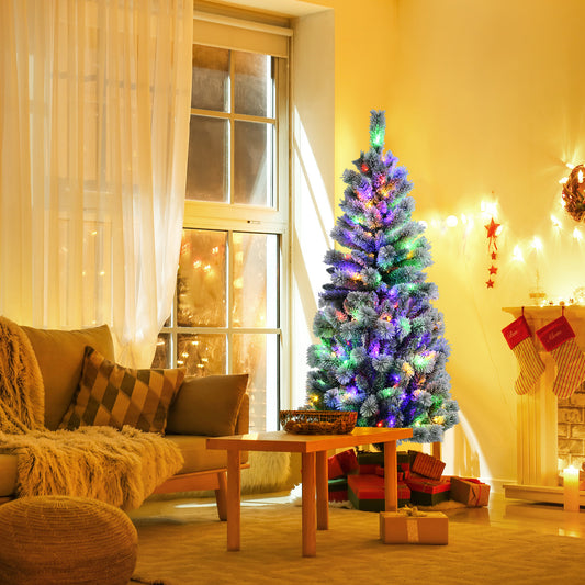 The Christmas tree decorated with colourful lights in a cosy living room next to a window