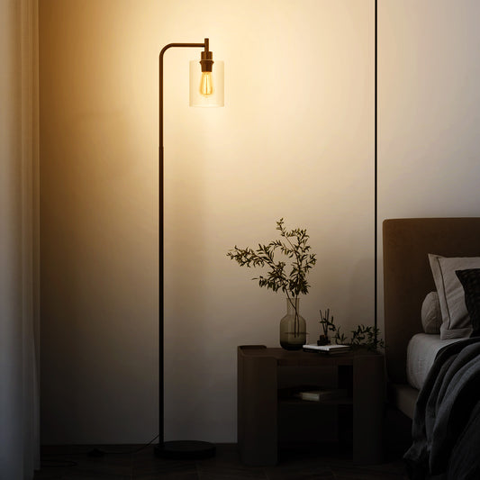 Industrial Floor Lamp, the lighting standing next to a bedside table in a bedroom with a warm glowing light