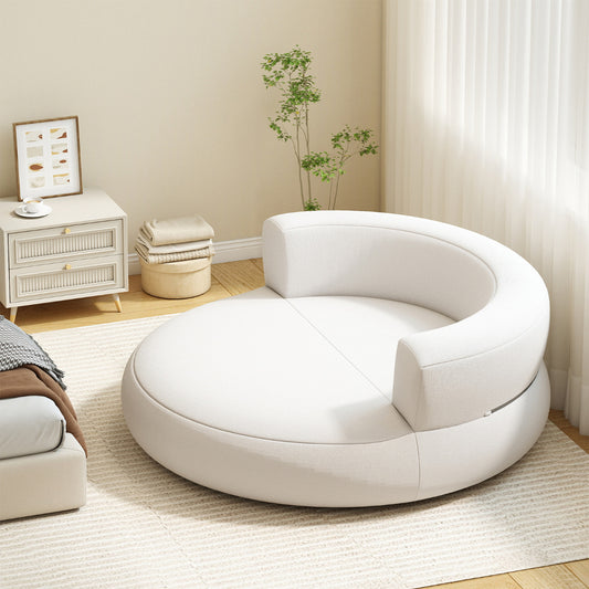 The inflatable sofa placed in a bright living room next to a bedside table and a rug