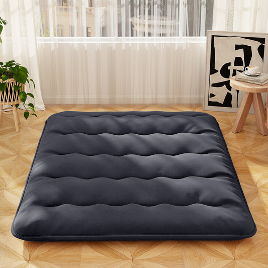 The black Japanese floor mattress laid flat on a wooden floor