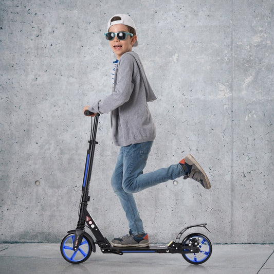 The kick scooter being ridden by a young boy wearing sunglasses and a grey hoodie