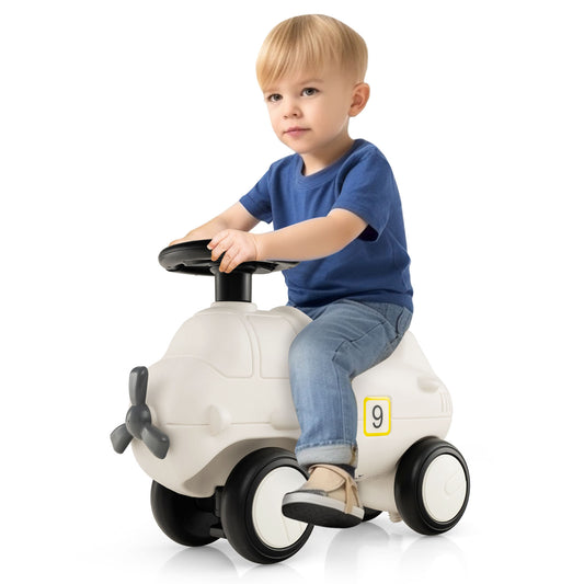 A young boy sitting on the push and pedal ride on toy in a bright indoor setting