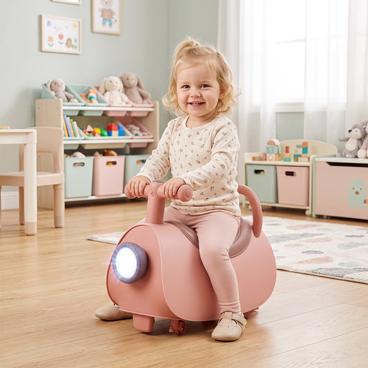 A happy toddler sits on the pink push and pedal ride on toy in a nursery