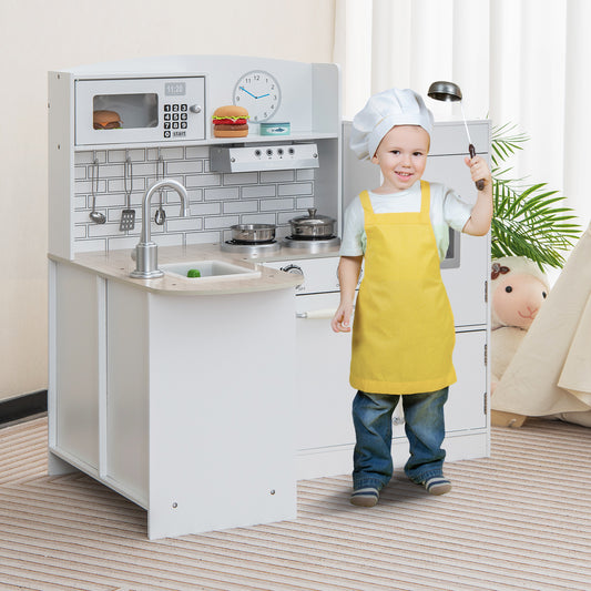 A young boy in a chef's hat and apron plays with the wooden corner play kitchen