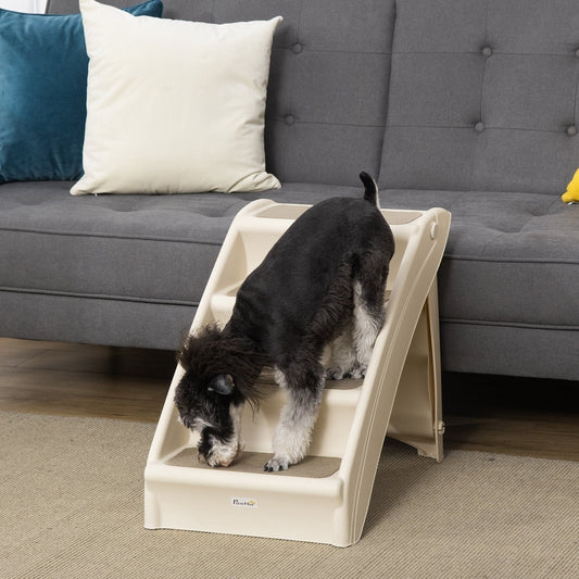 A small dog climbing the pet steps placed next to a grey sofa in a living room