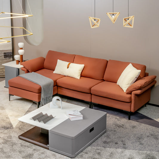The red sectional sofa styled in a modern living room with a coffee table and cushions
