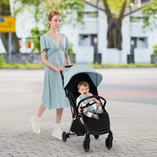 A woman pushing a baby in a blue lightweight baby stroller with a detachable seat cover