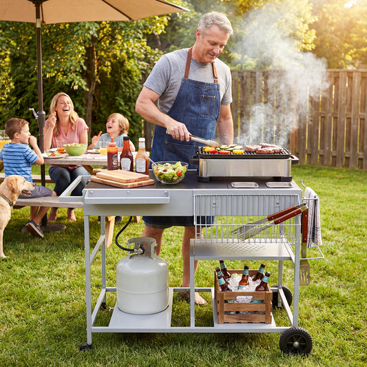 The outdoor grill being used by a man cooking food for his family in a sunny garden