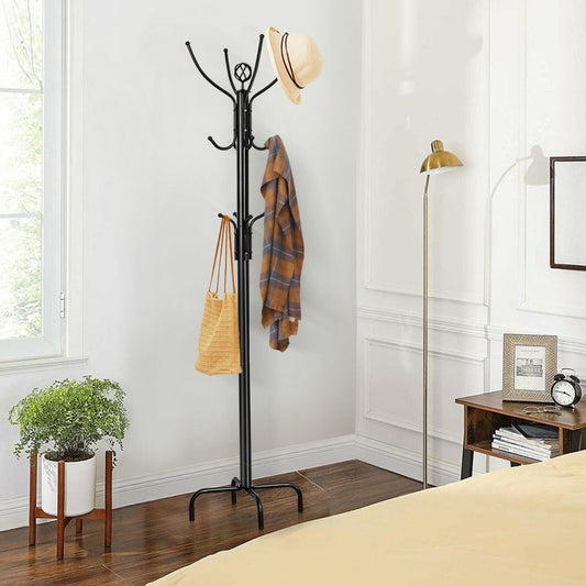 The coat rack is shown in a bedroom setting with a hat and coat hanging on it