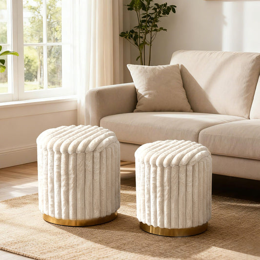 Two beige ottomans with gold bases on a rug in a living room