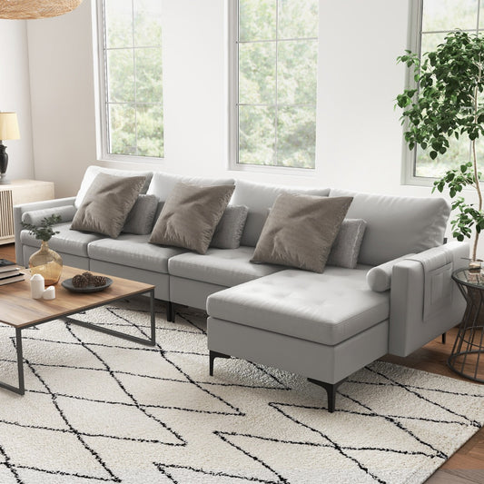 The grey sectional sofa styled in a bright living room with a coffee table and house plant