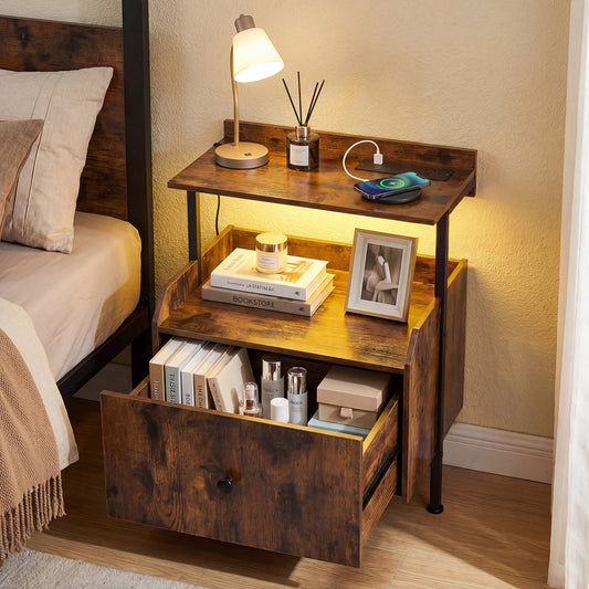 The bedside table with its drawer open, displaying books and toiletries, next to a bed