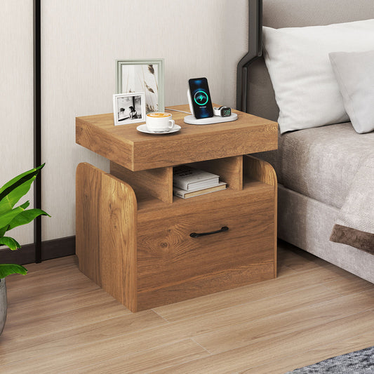The nightstand placed next to a bed with a phone charging on the top surface
