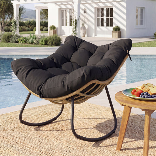 The oversized PE wicker patio egg chair with thick black cushion on a rug by a swimming pool