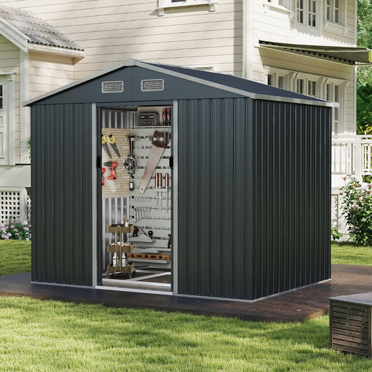 Grey metal outdoor storage shed with sloping top and sliding doors set up in a garden on a wooden deck