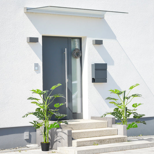 Two artificial cheese plants flanking a doorway on a patio