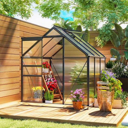 Walk-in polycarbonate greenhouse set up on a wooden deck with plants and flowers