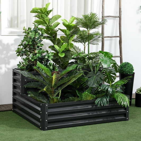 The galvanised planter box placed on a lawn with various indoor plants and a wooden ladder behind
