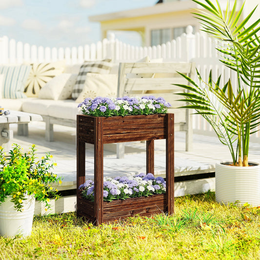 The wooden planter filled with purple and white flowers on a patio next to garden furniture