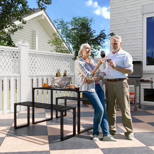 A couple enjoy drinks at the black picnic bench set in a garden setting